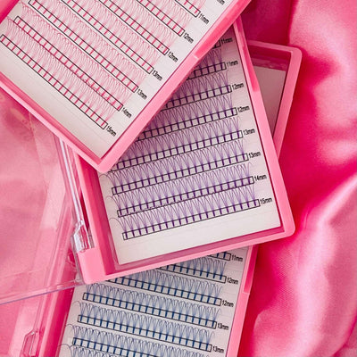 Pink lash extension trays featuring lengths 11mm, 12mm, and 13mm with mixed curl styles on soft pink satin background.