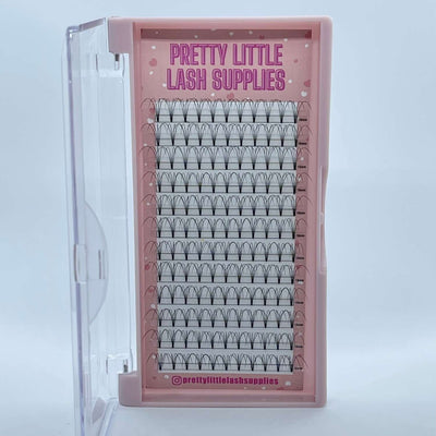 Clear eyelash extension tray in pink packaging, featuring multiple rows of black, pre-made fan lashes.