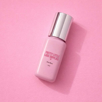 Pretty Little Lash Supplies Aria Glue, 10ml, pink bottle with silver cap, ideal for lash extensions.