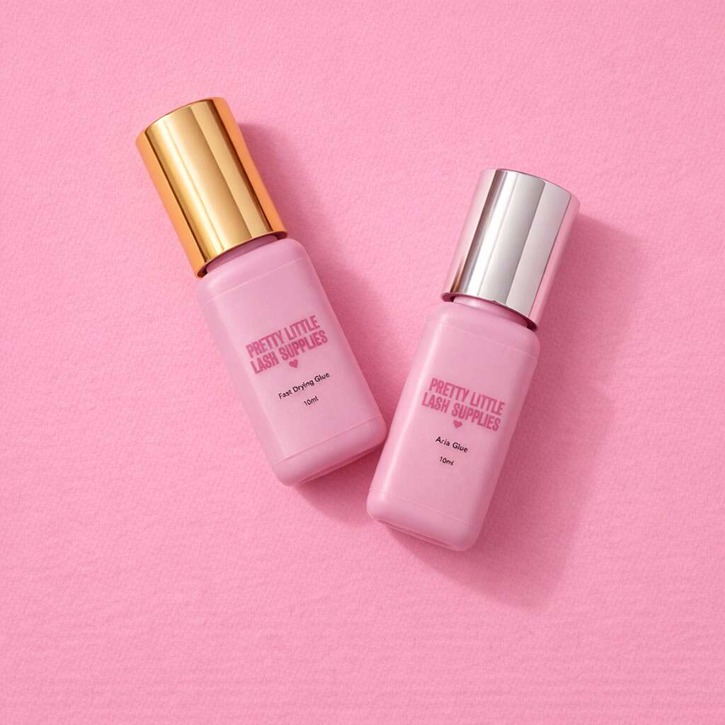 Two pink lash glue bottles with gold and silver caps, featuring "Pretty Little Lash Supplies" branding on a pink background.