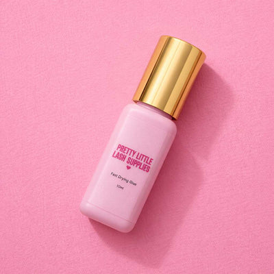 Pink fast-drying glue in a sleek bottle with a gold cap, perfect for lash application from Pretty Little Lash Supplies.