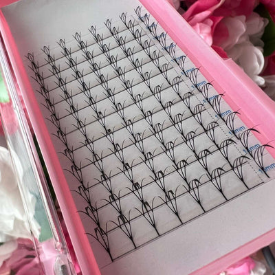Black individual eyelash extensions in a pink tray, featuring a soft, fairy style.