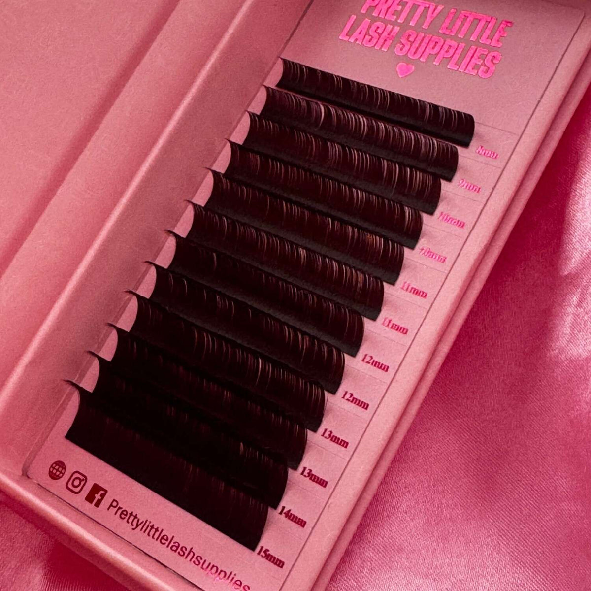 Black eyelash extension strips in a stylish pink packaging, featuring lengths from 8mm to 15mm for customizable looks.