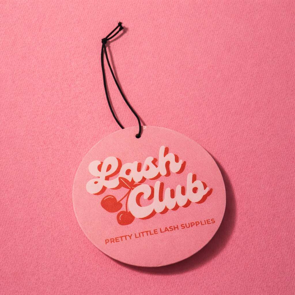 Pink circular car scent with "Lash Club" logo, featuring cherries and stylish typography for lash supply branding.