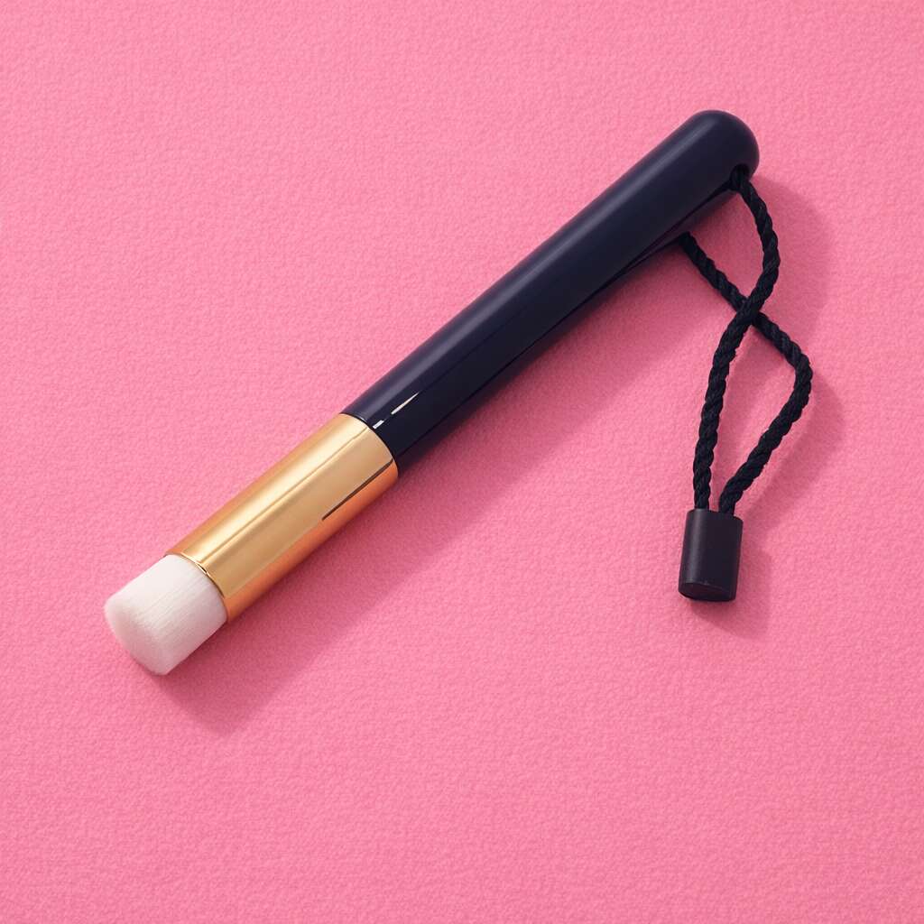 Navy blue makeup brush with a gold ferrule and white bristles, features a black strap for easy carrying.
