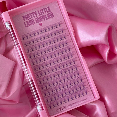 Pretty Little Lash Supplies pink lash tray with individual lashes in various lengths, set against soft pink satin fabric.