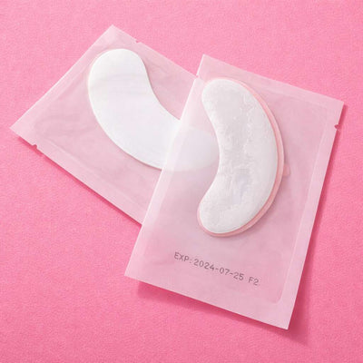 Hydrating eye masks in pink packaging, featuring a marbled white design, ideal for reducing puffiness and dark circles.