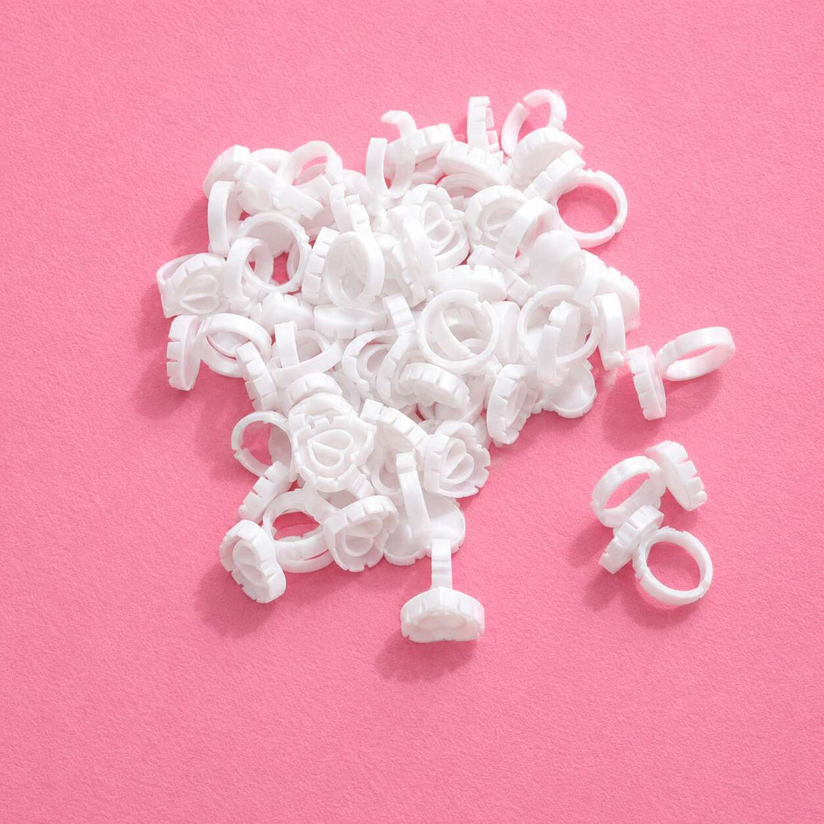 White plastic ring-shaped tags on a pink background, ideal for retail pricing and inventory management.