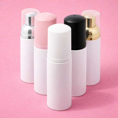 White, black, pink, gold, and silver spray bottles in a modern design, perfect for travel or personal care.