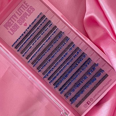 Blue silk eyelash extensions on a pink lash tray, featuring various lengths in a stylish presentation.