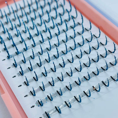 Blue lash extensions arranged neatly in a pink tray, highlighting a dramatic, stylish curl. Perfect for glam looks.