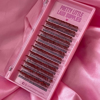 Black eyelash extensions in a clear pink case, featuring varying lengths for a voluminous look.