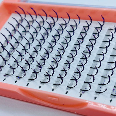 Purple and silver glitter eyelash extensions in a clear tray, curved design for dramatic volume and length.