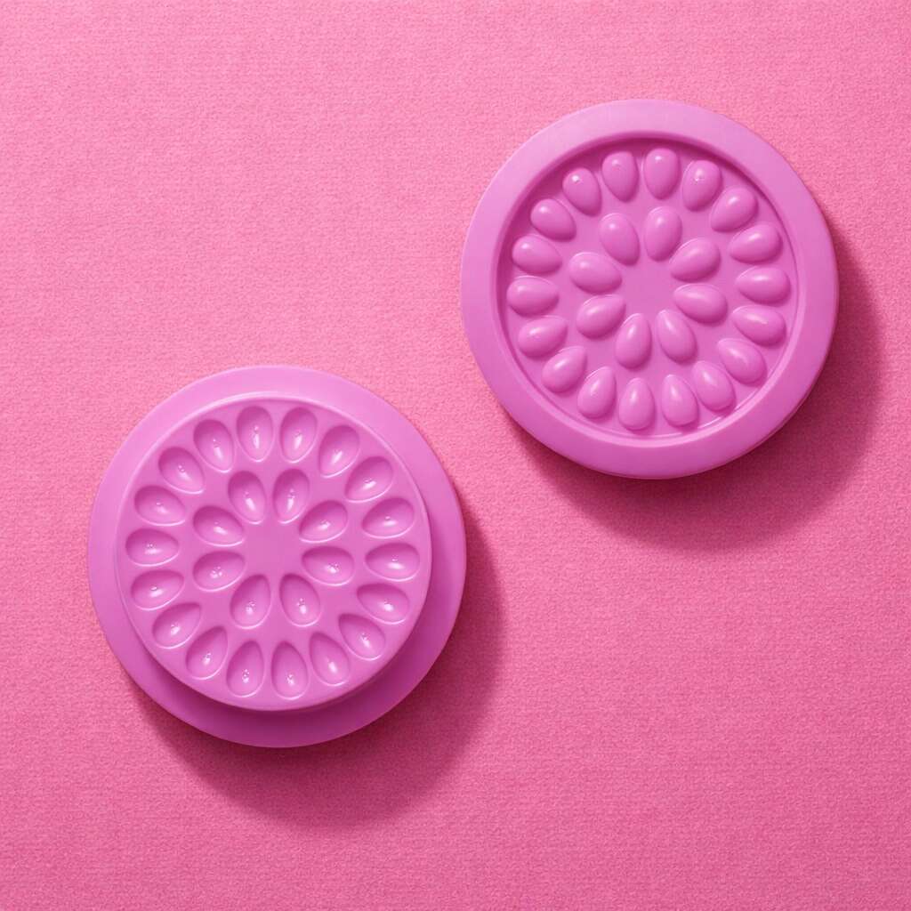 Set of two floral-patterned silicone coasters in vibrant pink, perfect for protecting surfaces from moisture.