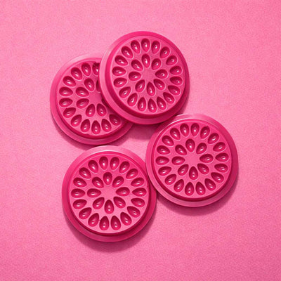 Set of four pink silicone coasters with a floral design, perfect for adding a pop of color to any table setting.
