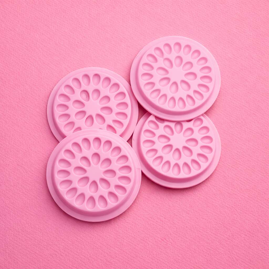 Set of four pink silicone coasters with floral pattern, perfect for protecting surfaces and adding style to your decor.