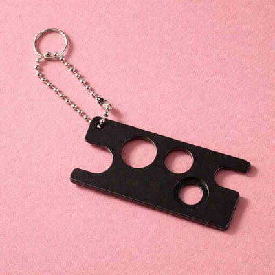 Black metal keychain bottle opener with three circular cutouts, elegantly designed for durability and style.