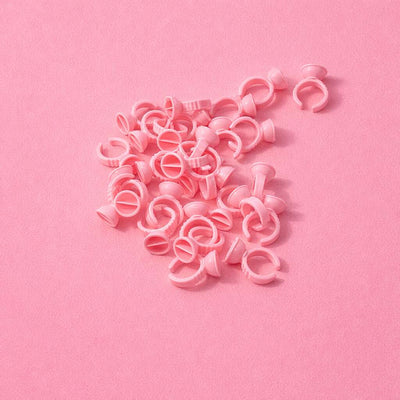Pink plastic hair clips scattered on a soft pink background, perfect for styling and organizing hair.