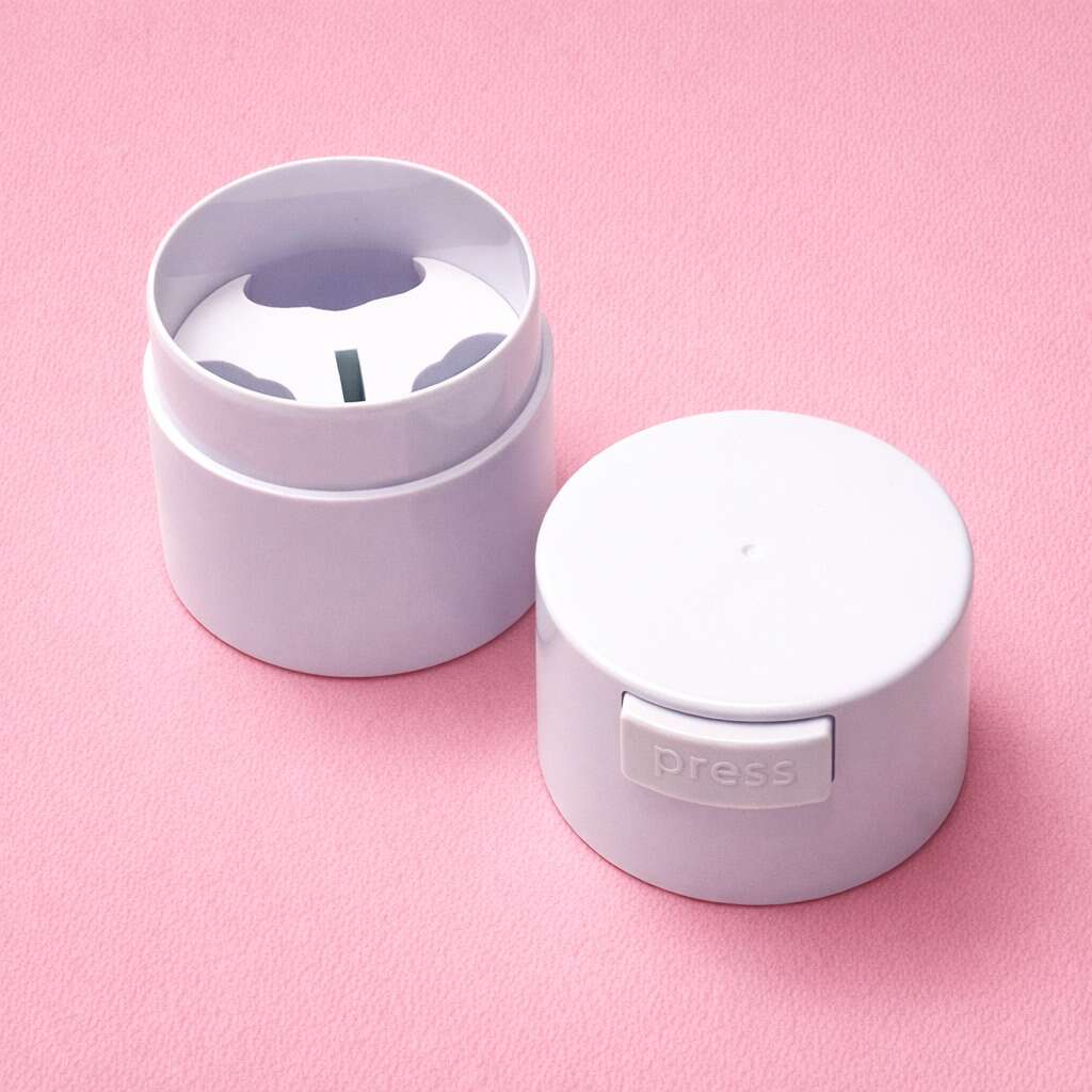 White plastic storage container with a press-top lid, featuring a rounded design, on a pink background.