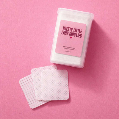 White lash pads with pink polka dots in a clear container, perfect for lash application and extensions. 200 count.