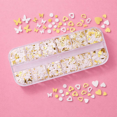 Gold and white glitter confetti shapes in a clear organizer, featuring hearts and butterflies, perfect for craft projects.