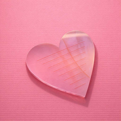 Pink heart-shaped acrylic serving tray with etched lines, perfect for home decor and special occasions.