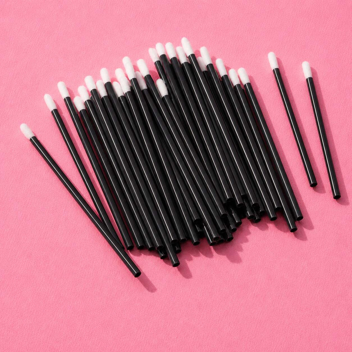 Black disposable makeup applicators with soft white tips, perfect for precise cosmetic application.