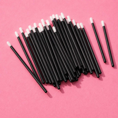 Black disposable makeup applicators with soft white tips, perfect for precise cosmetic application.
