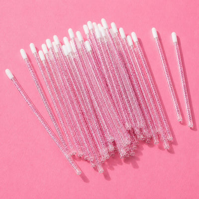 Pack of 50 clear pink glass stir sticks with white silicone tips, perfect for cocktails and coffee.