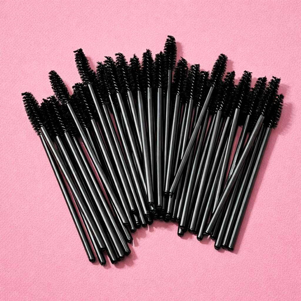 Set of 50 black mascara wands, ideal for makeup application and grooming, displayed against a pink background.