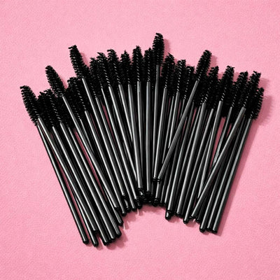 Set of 50 black mascara wands, ideal for makeup application and grooming, displayed against a pink background.