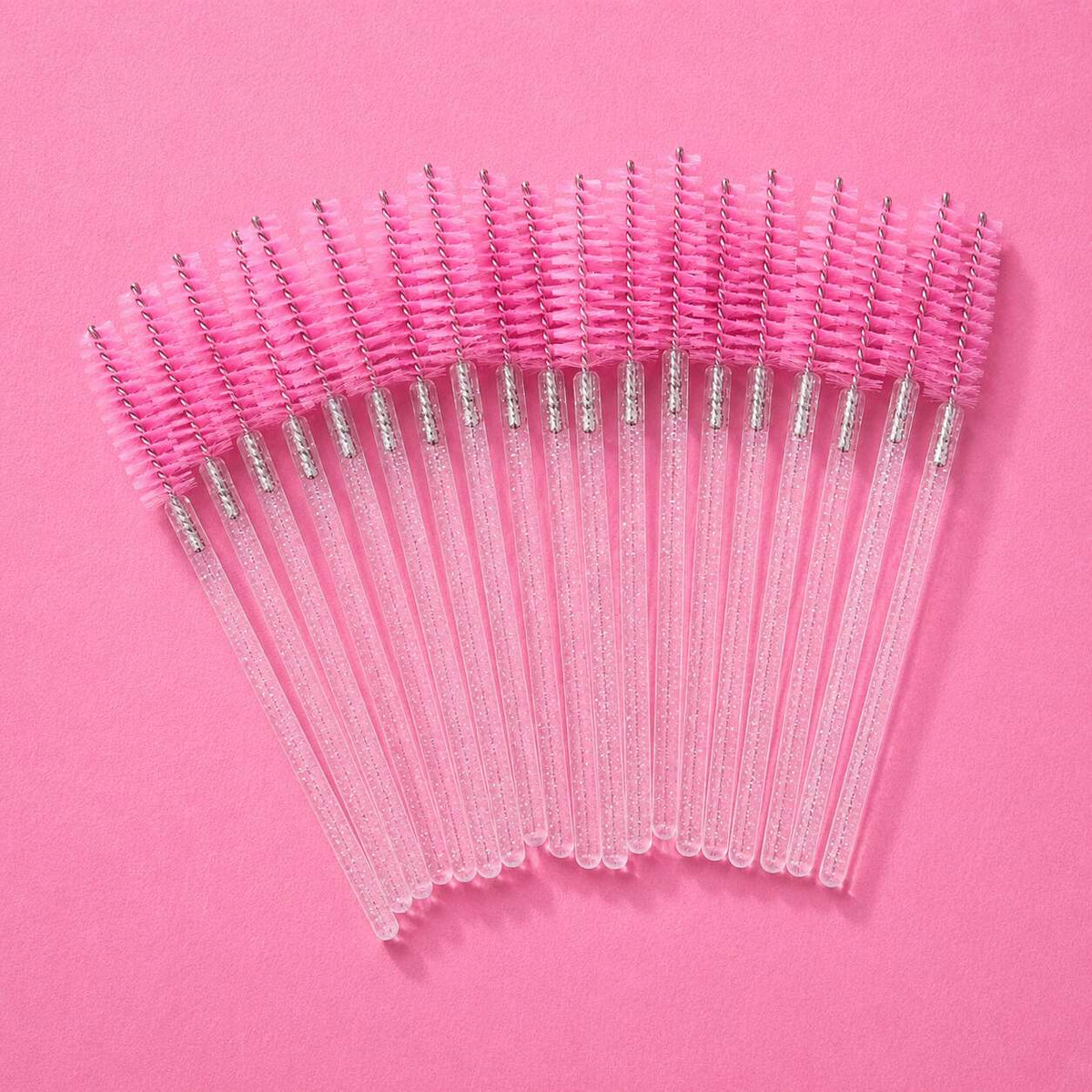 Set of 20 pink eyelash brushes with clear handles, perfect for makeup application and grooming.
