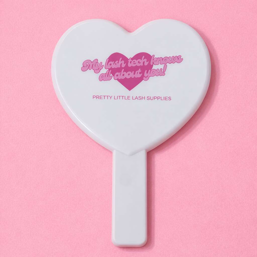 White heart-shaped cosmetic mirror with pink text "My lash tech knows all about you!" from Pretty Little Lash Supplies.