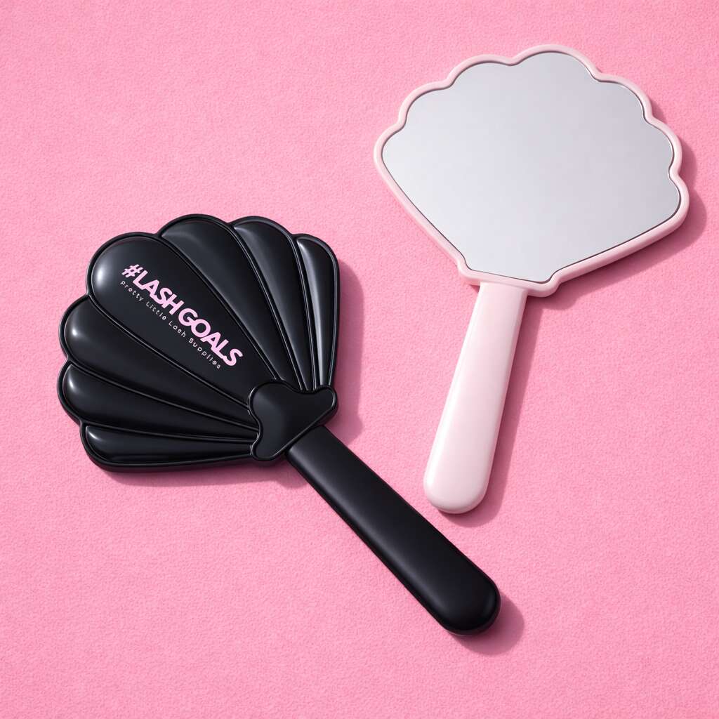 Black shell-shaped mirror with "#LASHGOALS" text and a pink hand-held mirror on a pink background.
