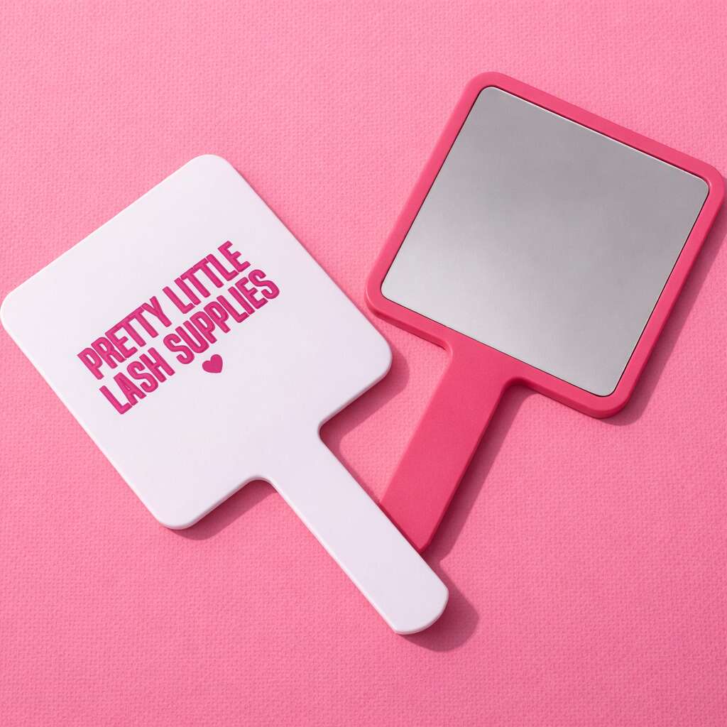 Pink and white handheld mirror with "Pretty Little Lash Supplies" text, perfect for beauty enthusiasts.
