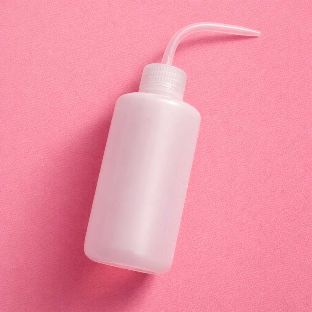 White plastic squeeze bottle with a curved nozzle on a pink background, ideal for sauces or liquids.