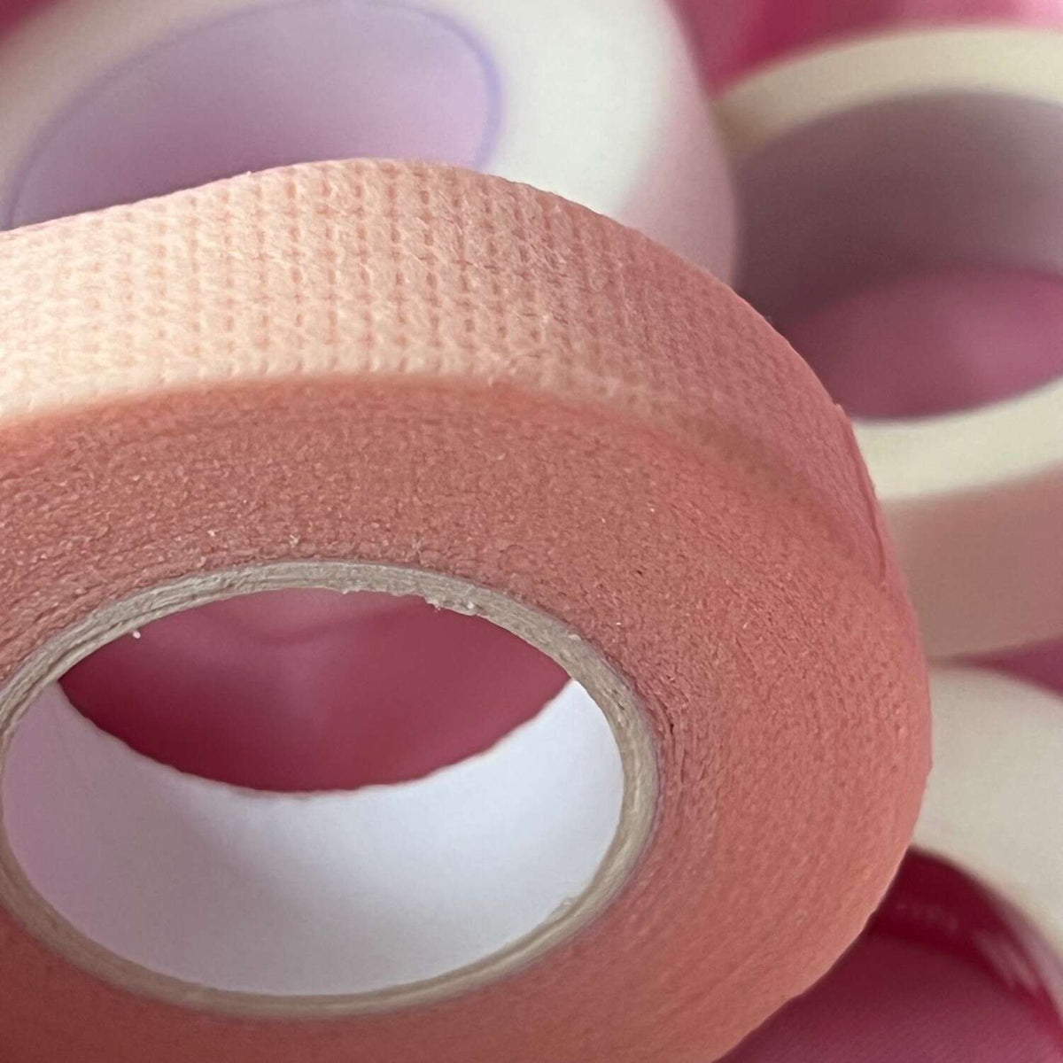 Peach washi tape roll with textured finish, perfect for crafting and scrapbooking.