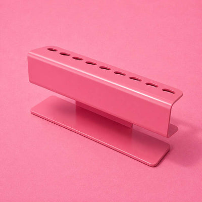 Pink metal desk organizer with multiple pen slots, modern design perfect for office or home decor.