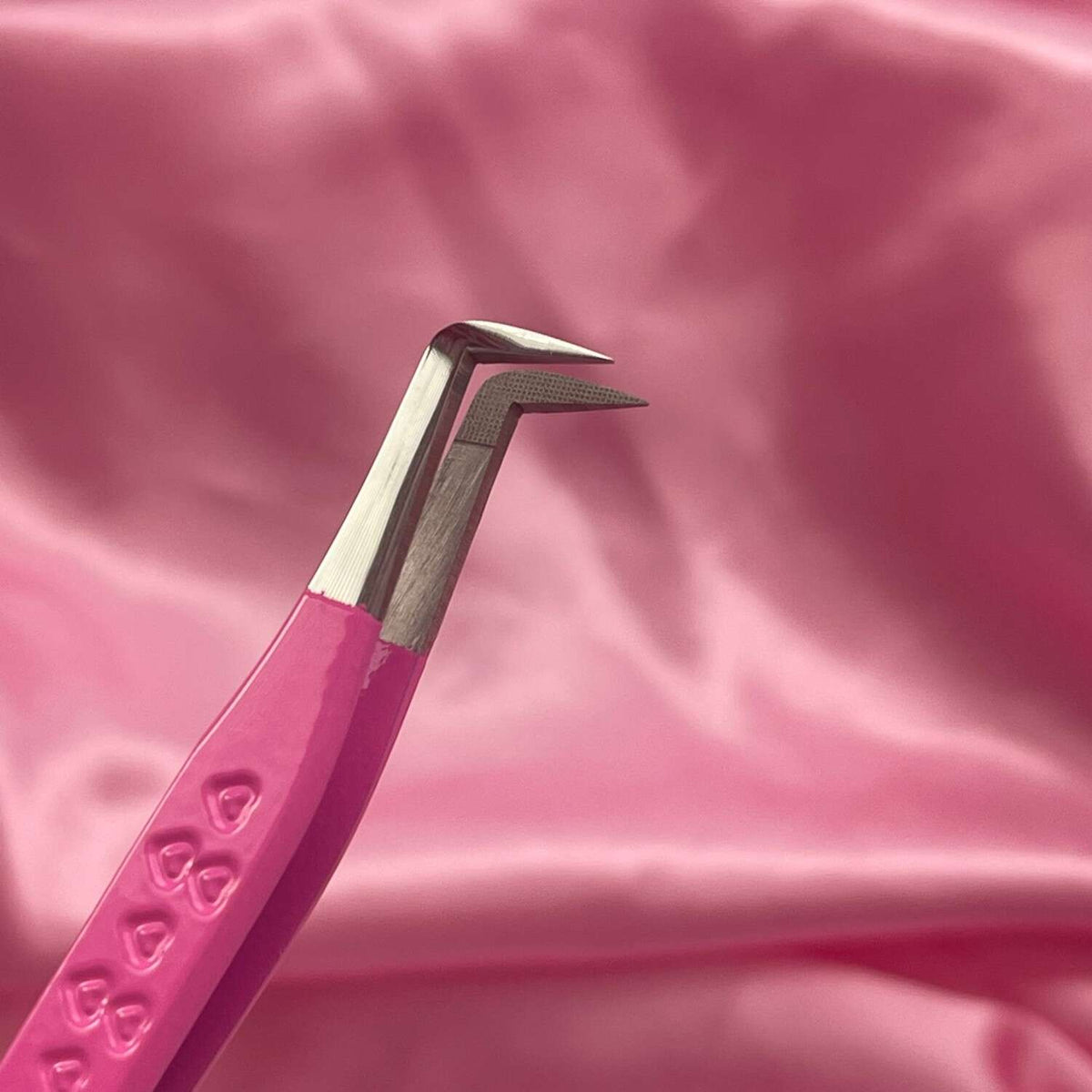 Pink stainless steel precision tweezers with a unique angled tip, perfect for beauty and grooming tasks.