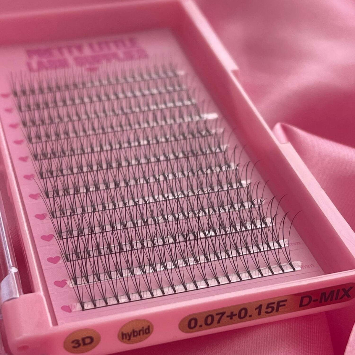 Whispy pre-made eyelash extensions in black, displayed in a pink palette, perfect for professional use.